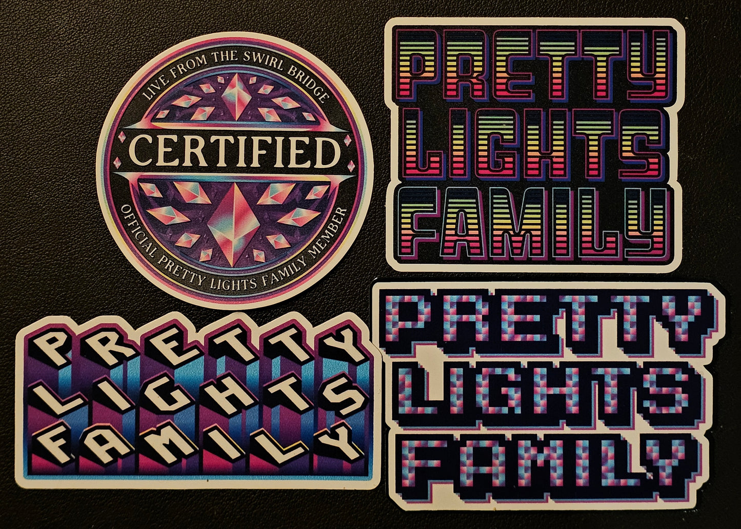Four 'Pretty Lights Family' branded stickers on a black background